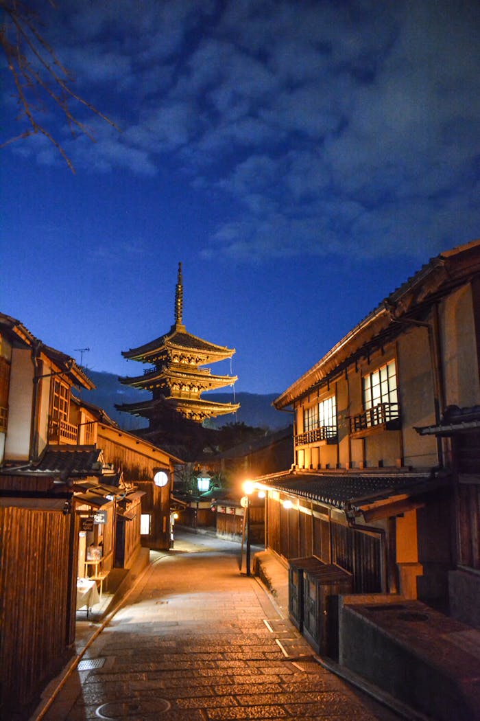 Twilight scene of the Yasaka Pagoda in Kyotos historic district with traditional wooden architecture.